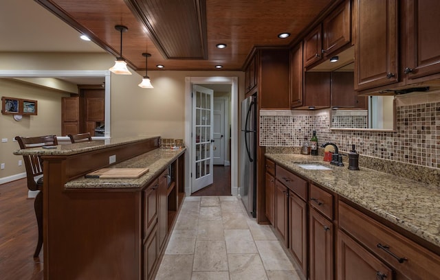 870 Mcmeekin Pl, Lexington, KY 40502 - kitchen with a sink, freestanding refrigerator, baseboards, a kitchen breakfast bar, and tasteful backsplash