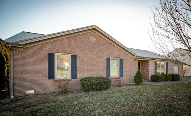 view of front facade with a front lawn, an attached garage, and brick siding