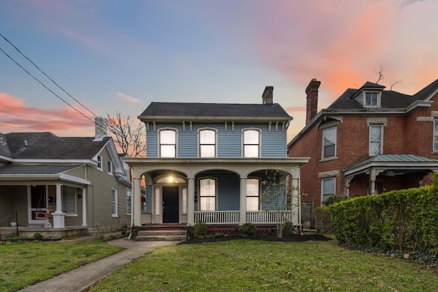 view of front of house with a chimney, a front lawn, and a porch