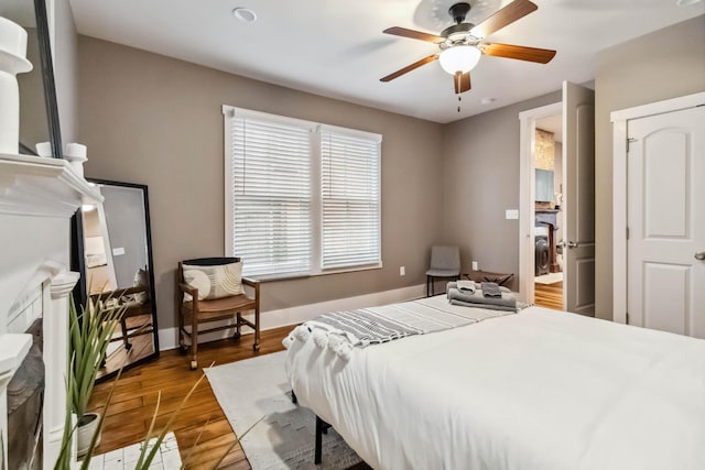 bedroom featuring baseboards, wood finished floors, and ceiling fan