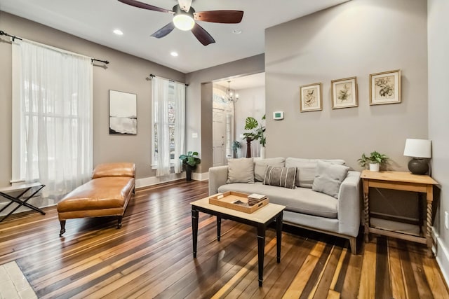 living area featuring ceiling fan with notable chandelier, recessed lighting, baseboards, and hardwood / wood-style flooring