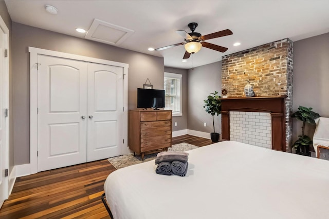 bedroom featuring a closet, ceiling fan, wood finished floors, and attic access