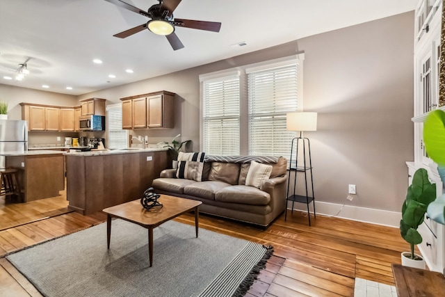 living area featuring hardwood / wood-style floors, recessed lighting, baseboards, and ceiling fan