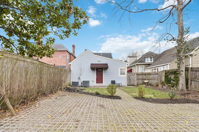 rear view of house with a fenced backyard and central air condition unit