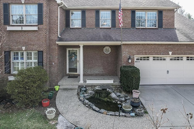view of front of property with concrete driveway, brick siding, and a shingled roof