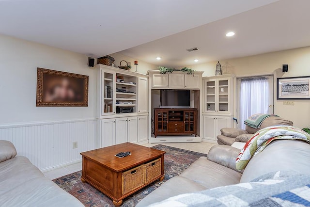 living room featuring a wainscoted wall, light tile patterned flooring, recessed lighting, and visible vents