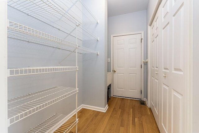 walk in closet featuring wood finished floors and visible vents