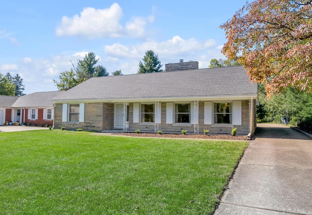 ranch-style home with roof with shingles, a chimney, concrete driveway, and a front yard