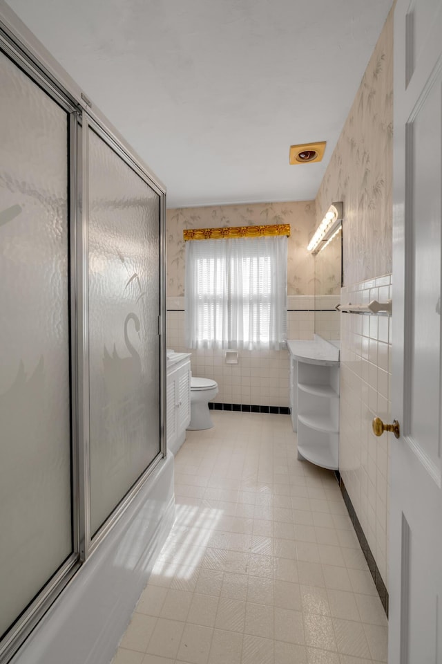 bathroom with wallpapered walls, tile walls, toilet, and vanity