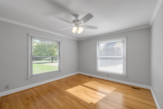 spare room featuring visible vents, ceiling fan, baseboards, ornamental molding, and wood finished floors