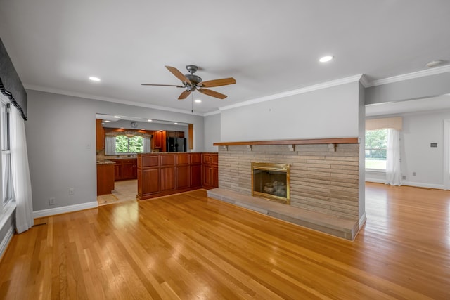 unfurnished living room featuring light wood-style flooring, baseboards, ceiling fan, and ornamental molding