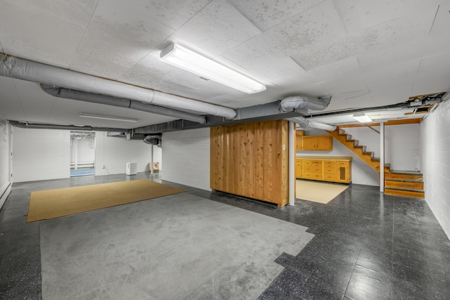 finished basement featuring stairway and concrete block wall
