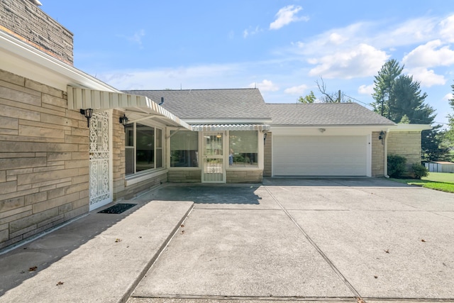 view of front of property with a garage, driveway, and a shingled roof