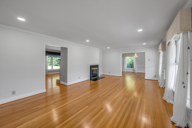 unfurnished living room with light wood-style flooring, recessed lighting, baseboards, and ornamental molding