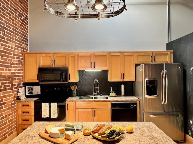 kitchen featuring brick wall, black appliances, a towering ceiling, and a sink