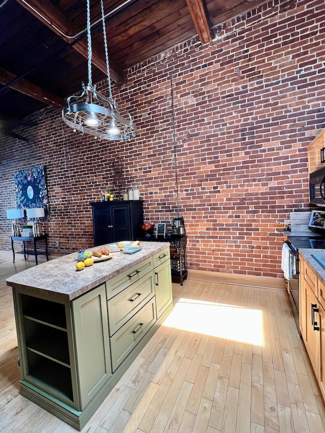 kitchen featuring green cabinetry, light wood-type flooring, beam ceiling, black appliances, and open shelves