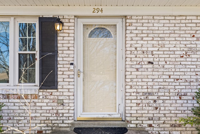 entrance to property featuring brick siding
