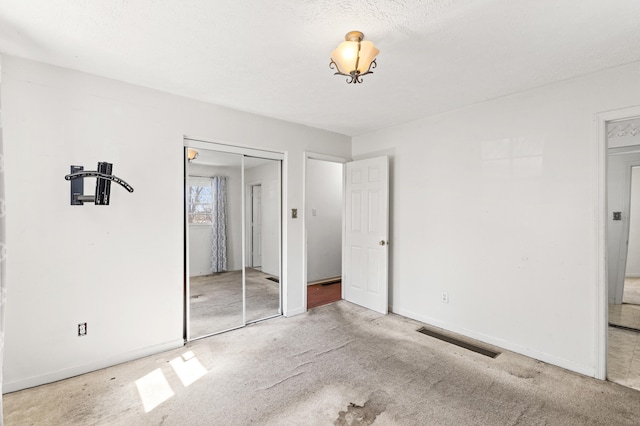 unfurnished bedroom featuring a closet, visible vents, carpet flooring, and baseboards