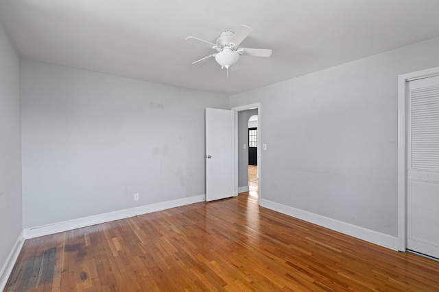 spare room with baseboards, a ceiling fan, and hardwood / wood-style flooring