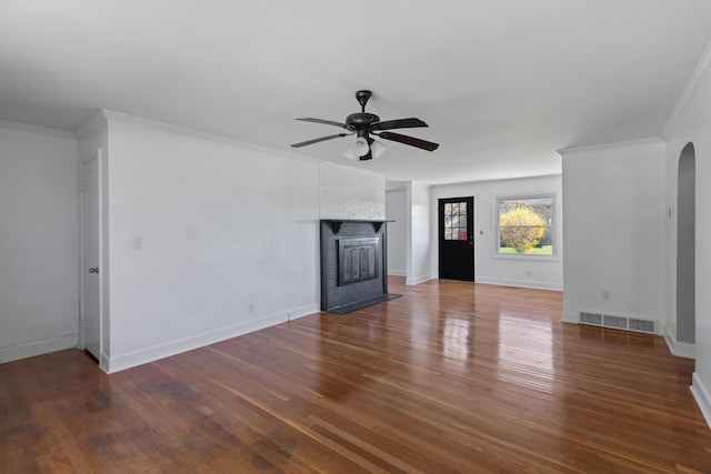 unfurnished living room featuring arched walkways, visible vents, a ceiling fan, and wood finished floors