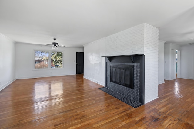 unfurnished living room featuring a brick fireplace, a ceiling fan, and wood-type flooring