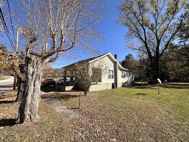 view of home's exterior with a lawn and a chimney