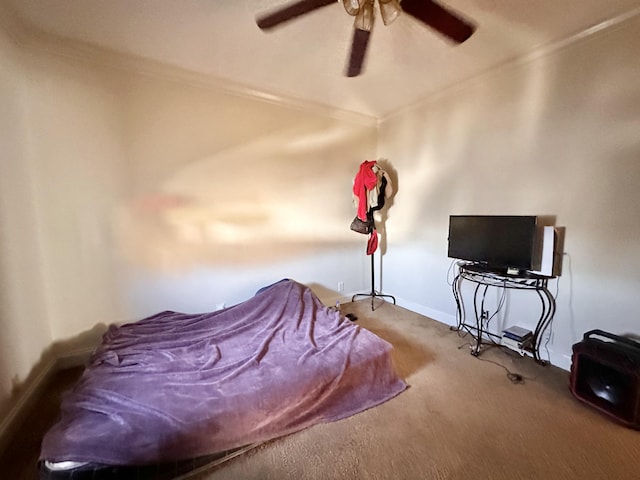 carpeted bedroom with ornamental molding, baseboards, and ceiling fan