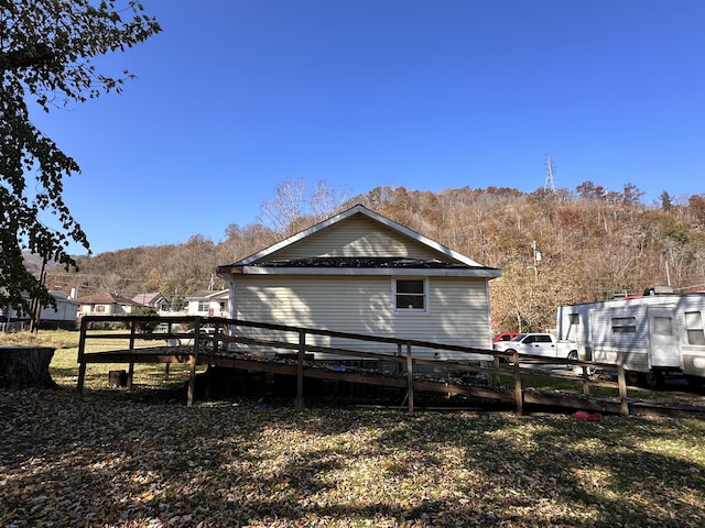 view of side of property with fence and a wooden deck