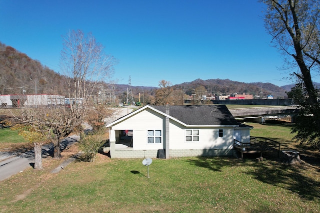 view of side of home featuring a yard and a mountain view