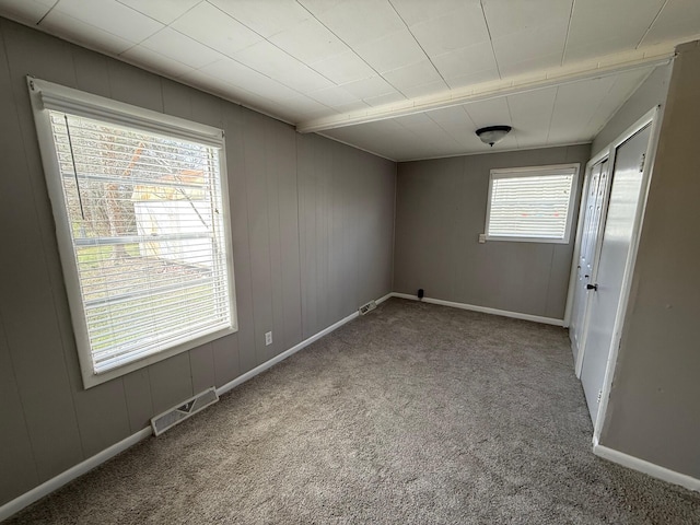 unfurnished room featuring visible vents, baseboards, and carpet