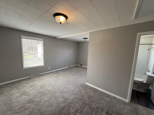 carpeted spare room featuring visible vents and baseboards