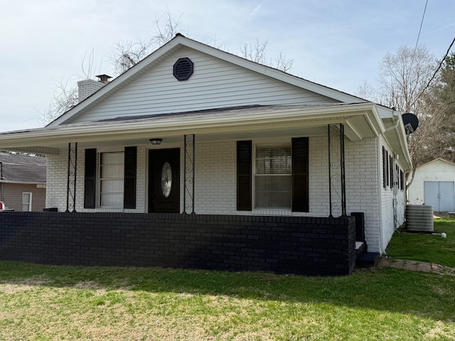 bungalow with central air condition unit, brick siding, and covered porch