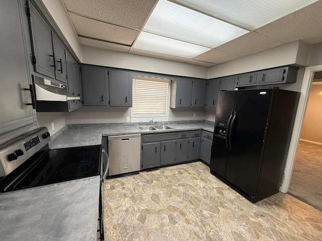 kitchen featuring a drop ceiling, gray cabinetry, stainless steel appliances, and a sink