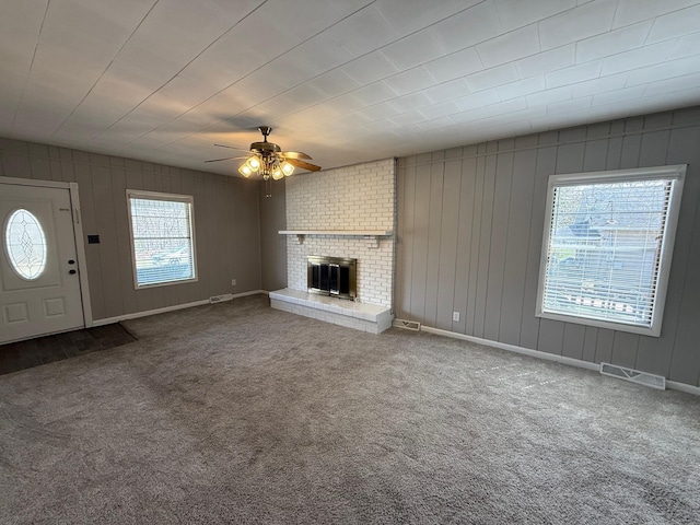 unfurnished living room with visible vents, a healthy amount of sunlight, and carpet flooring