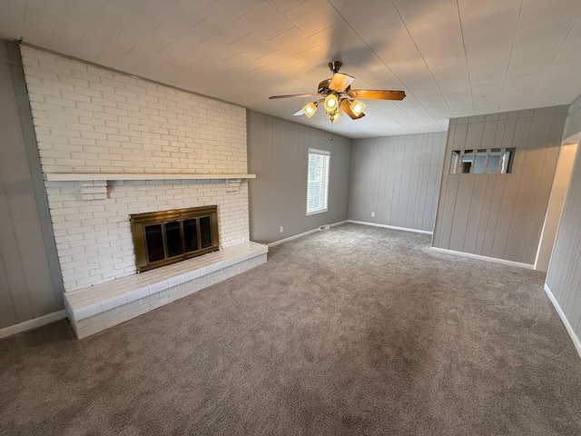 unfurnished living room featuring carpet, a ceiling fan, baseboards, and a fireplace