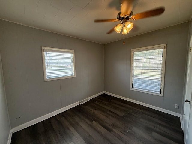 unfurnished room featuring visible vents, baseboards, dark wood-type flooring, and ceiling fan