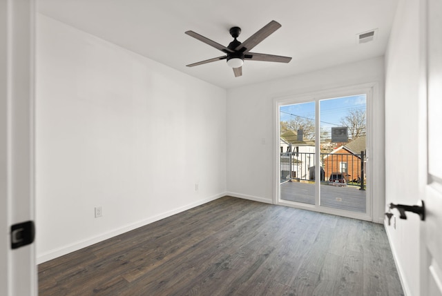 empty room featuring visible vents, baseboards, a ceiling fan, and dark wood finished floors