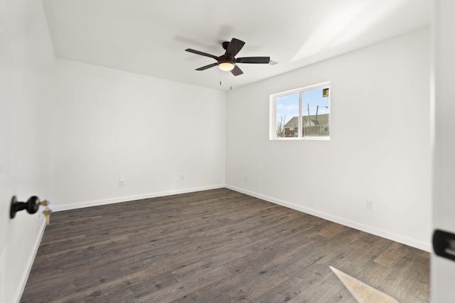 spare room with dark wood-style floors, baseboards, and a ceiling fan
