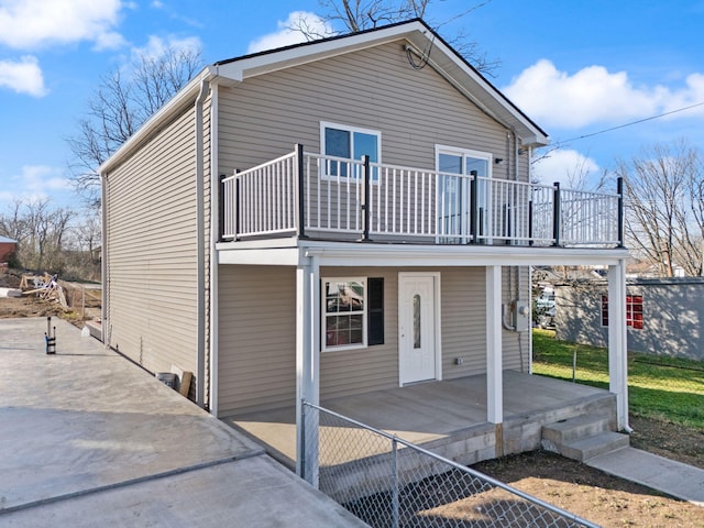 rear view of property with a yard, a porch, and fence
