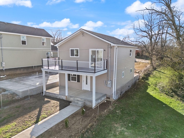 rear view of house with a deck, a yard, fence, and crawl space