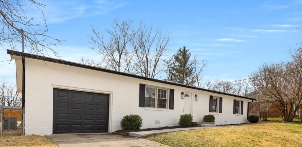 view of front of property featuring driveway, a front yard, and a garage