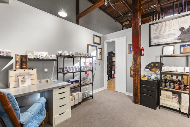 carpeted office space with a towering ceiling and baseboards
