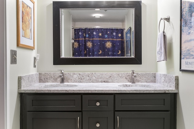 bathroom with double vanity, a sink, and curtained shower