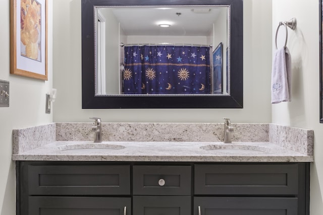 bathroom featuring double vanity, a shower with shower curtain, and a sink