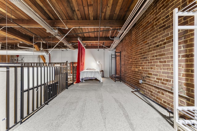 interior space featuring wooden ceiling, carpet floors, and brick wall