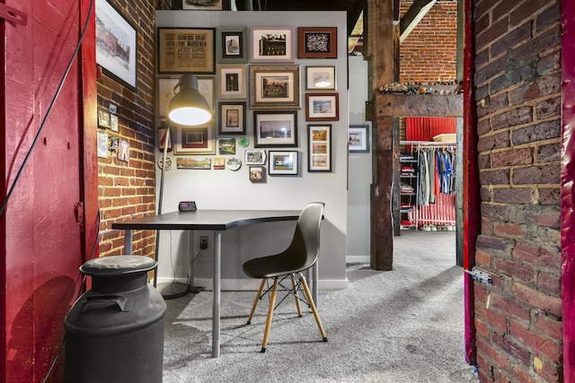carpeted office with baseboards and brick wall