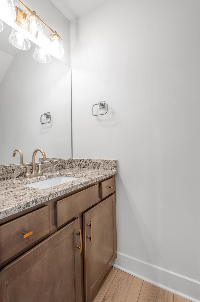 bathroom featuring baseboards, wood finished floors, and vanity