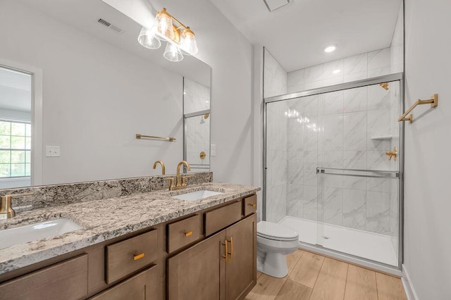 full bathroom featuring visible vents, a sink, toilet, and a shower stall