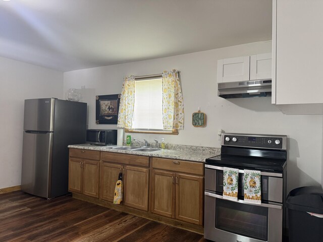 104 First St, Cynthiana, KY 41031 - kitchen with appliances with stainless steel finishes, under cabinet range hood, a sink, dark wood-style flooring, and brown cabinets