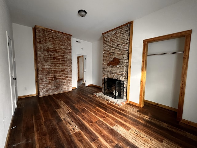 104 First St, Cynthiana, KY 41031 - unfurnished living room with wood finished floors, a brick fireplace, and baseboards